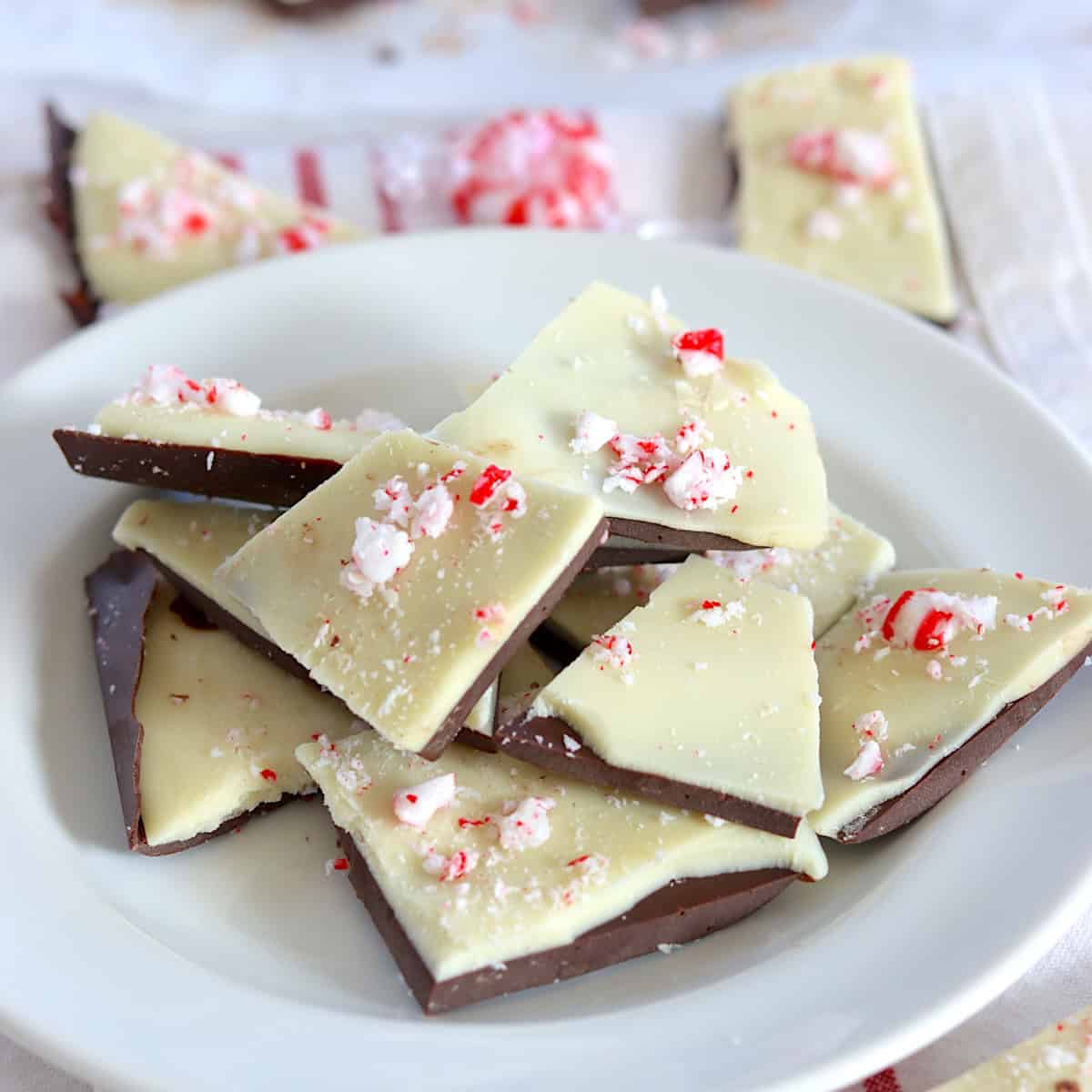 Pieces of sugar free peppermint bark on a white round plate.