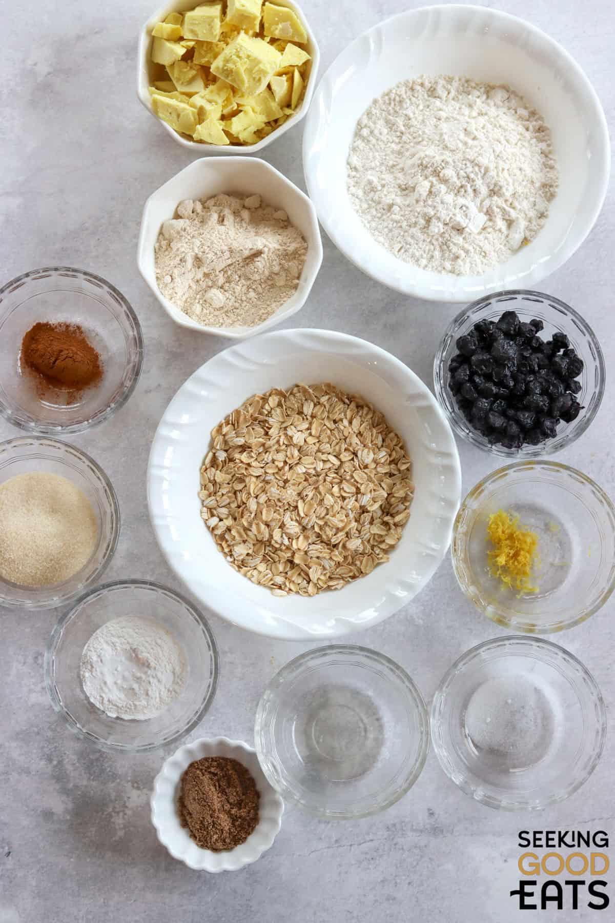 Ingredients needed to make vegan lemon blueberry scones on a white marble countertop.