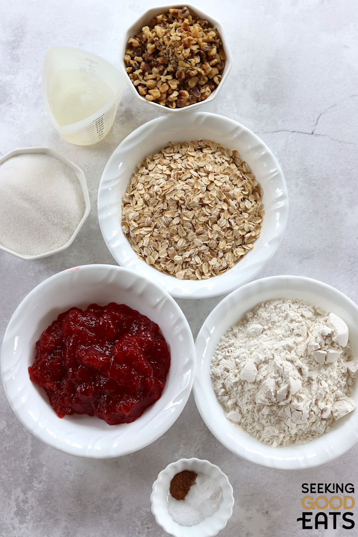 Ingredients needed to make strawberry oatmeal bars on a white marble countertop.