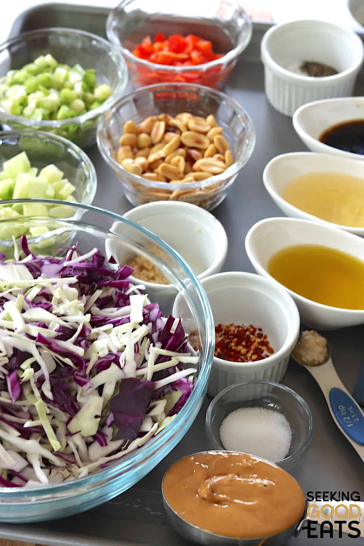 Ingredients needed for making thai salad with peanut dressing on a metal tray.