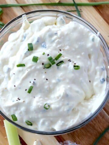 Chunky homemade blue cheese dressing in a clear glass bowl.