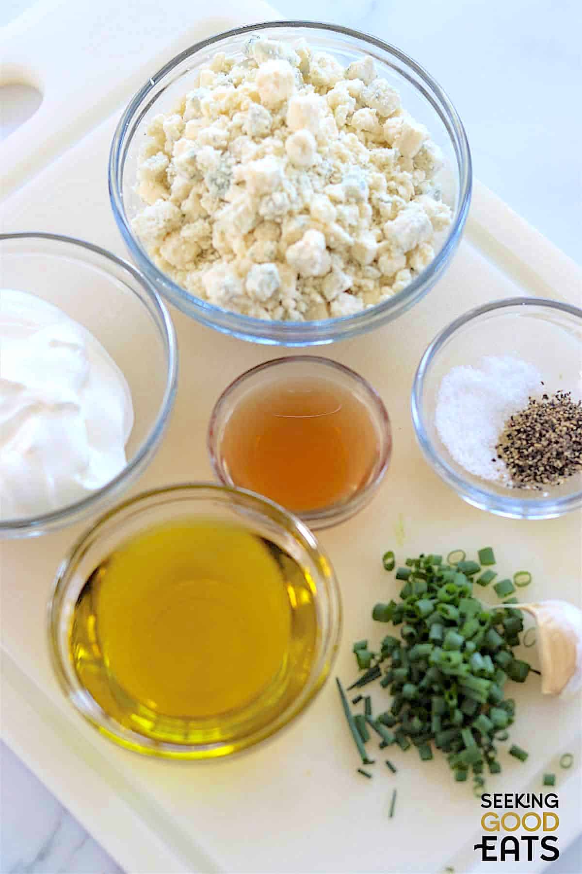 Ingredients needed for making the best blue cheese dressing on a white cutting board.