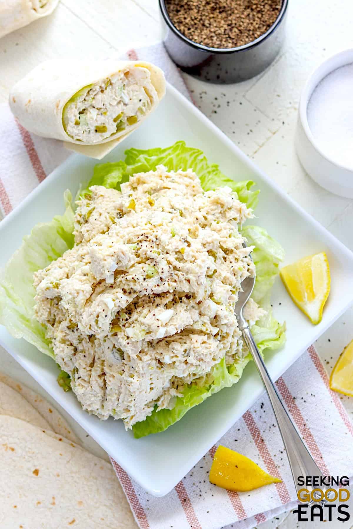 A white square plate with copycat Chick-fil-a chicken salad on a bed of lettuce.