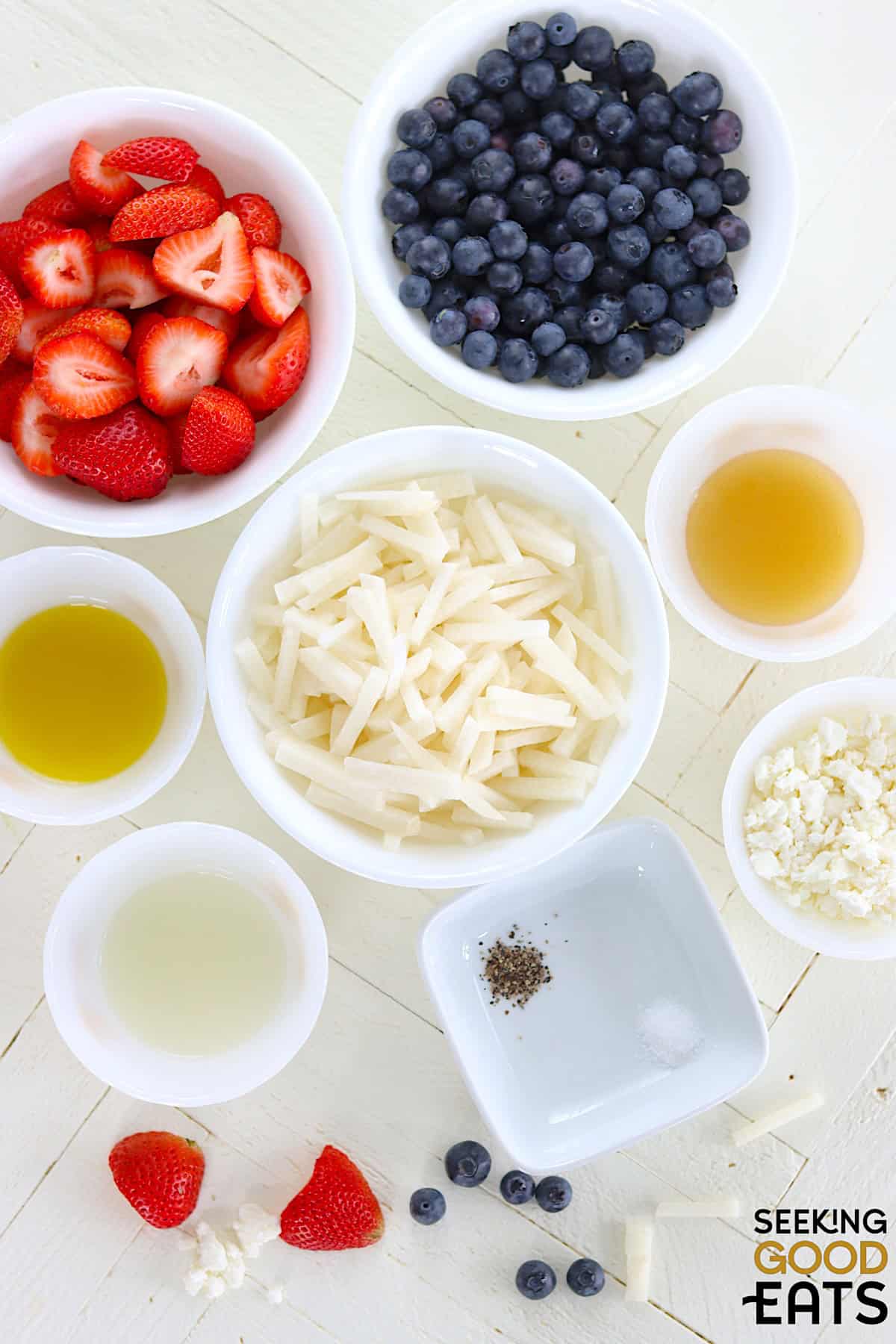Ingredients for red white and blue fruit salad on a white countertop.