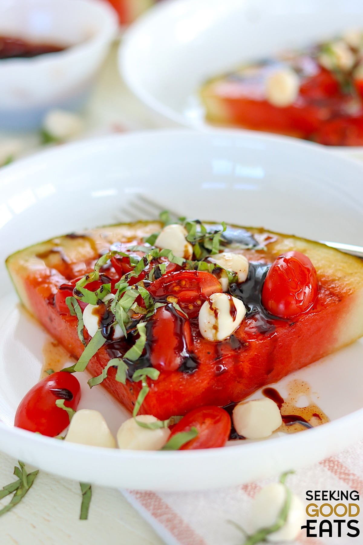 Grilled watermelon caprese with mozzareall pearls basil and cherry tomatoes.