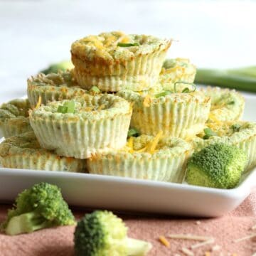 Broccoli cheddar egg bites stacked on a white square plate.